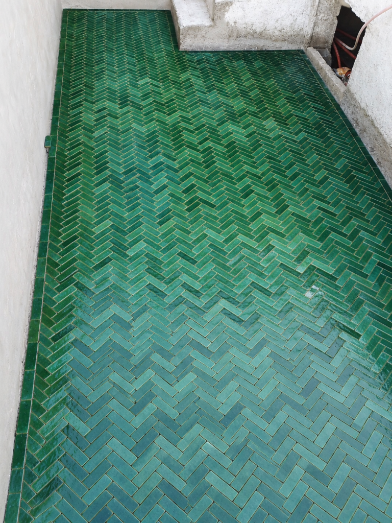 Sol en petits carreaux verts disposés en chevrons